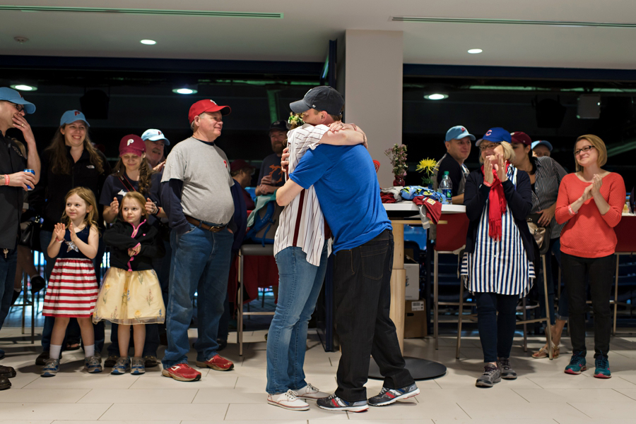 A bride and groom hug in the suite at the Phillies game wedding.